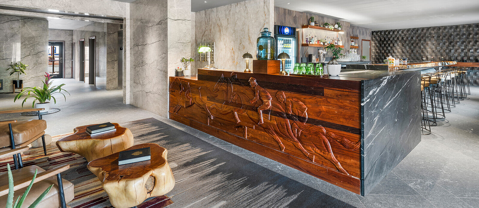 A lobby bar with a wooden front and marble countertop