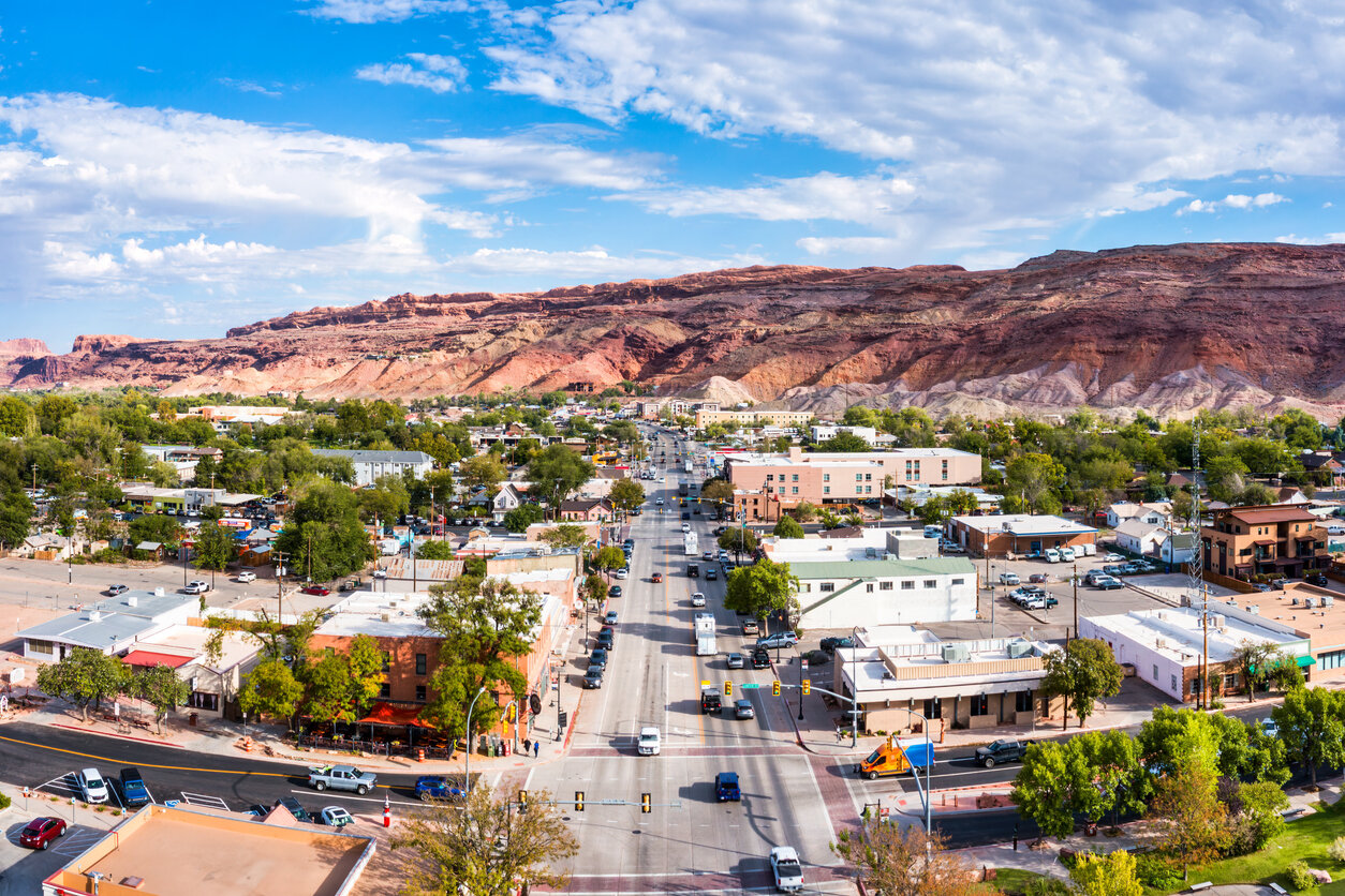Aerial view of a city street with buildings and a mountain in the background